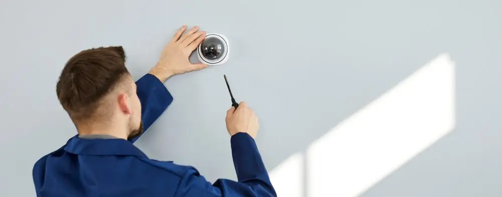 young,man,installing,modern,security,camera,for,theft,deterrence,inside